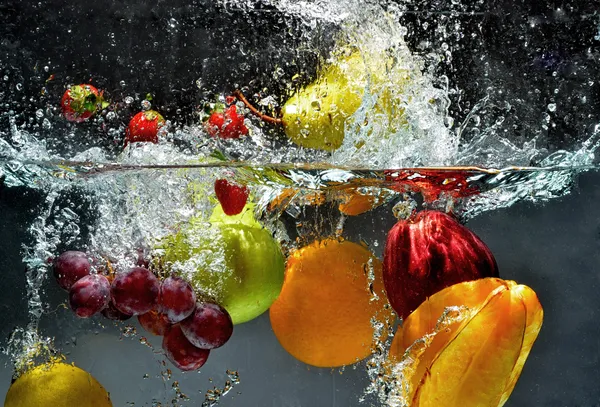 Свежие фрукты, плещущиеся в воду — стоковое фото